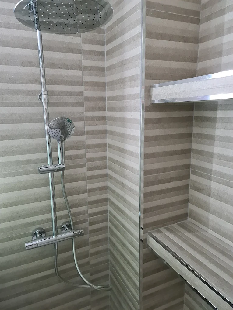 Reforma de ducha lluvia de techo con columna y banco de piedra - Reformas Integrales Arias Madrid